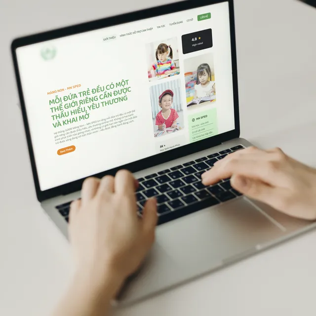 Hand using laptop displaying preschool landing page